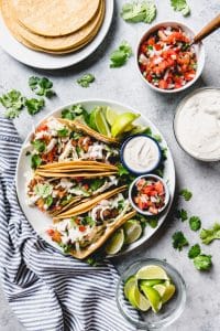 an aerial view of Baja Fish Tacos on a plate with ingredients scattered and placed around the plate too