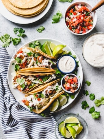 an aerial view of Baja Fish Tacos on a plate with ingredients scattered and placed around the plate too