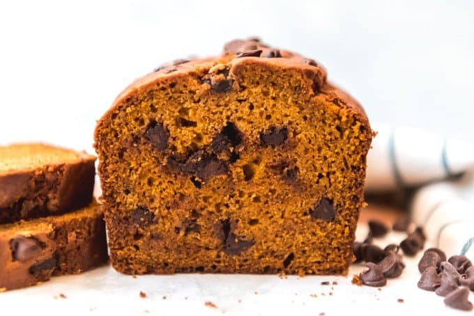 An image of a sliced loaf of moist pumpkin spice bread loaded with chocolate chips.