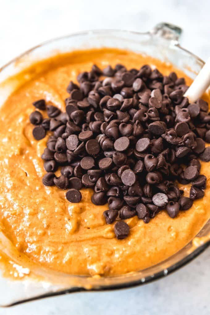 An image of pumpkin bread batter with semisweet chocolate chips on top, ready to be mixed in.