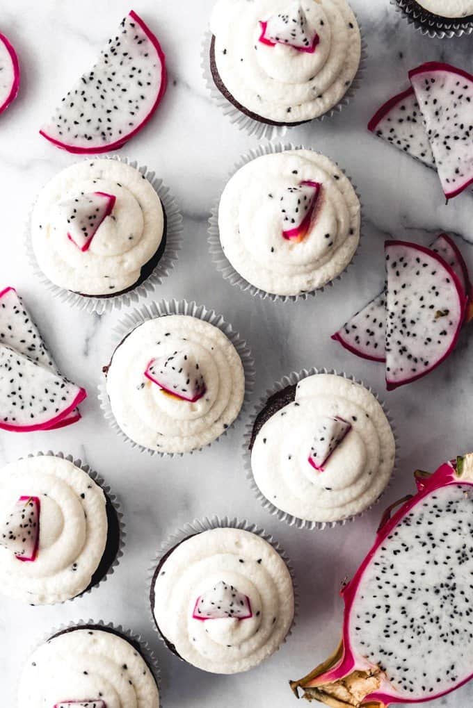 An image of chocolate cupcakes with fresh dragon fruit frosting and slices of dragon fruit.