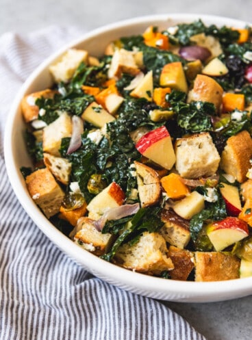 A white bowl filled with Fall Panzanella Salad.