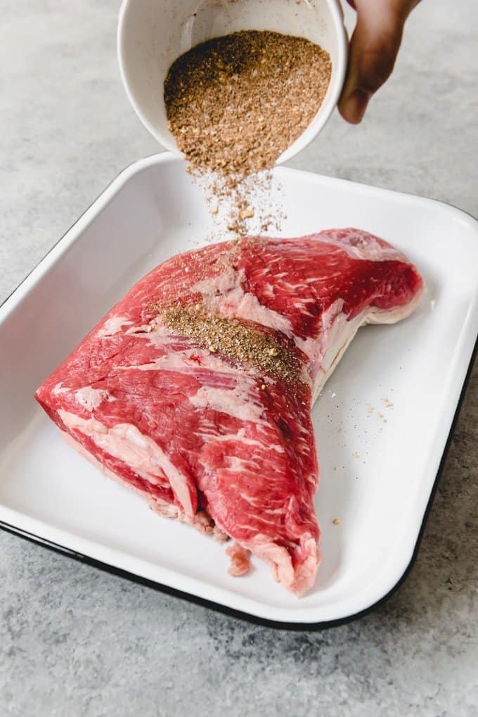 An image of a tri-tip roast being sprinkled with Santa Maria rub.