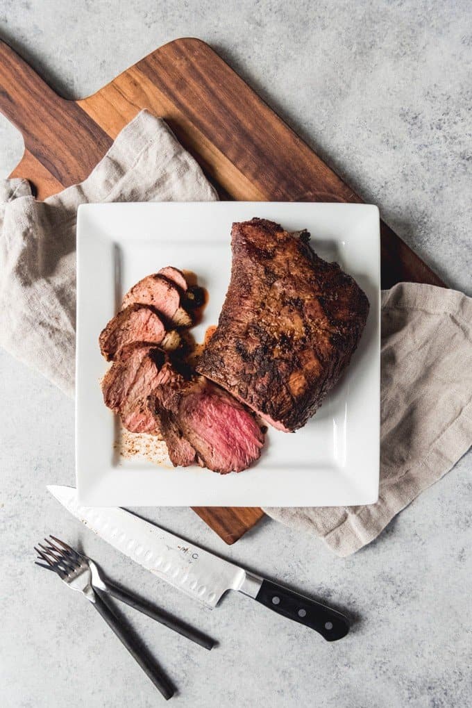 An image of a grilled tri-tip roast cooked medium-rare, sliced against the grain.