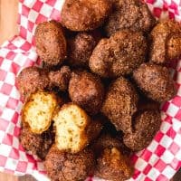 an aerial view of a bowl of southern hush puppies and one split open