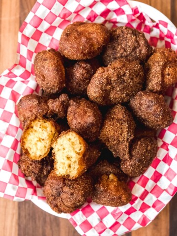 an aerial view of a bowl of southern hush puppies and one split open