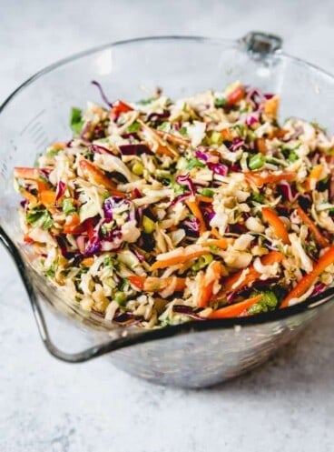 Asian Slaw with Ginger Peanut Dressing in a large glass measuring bowl