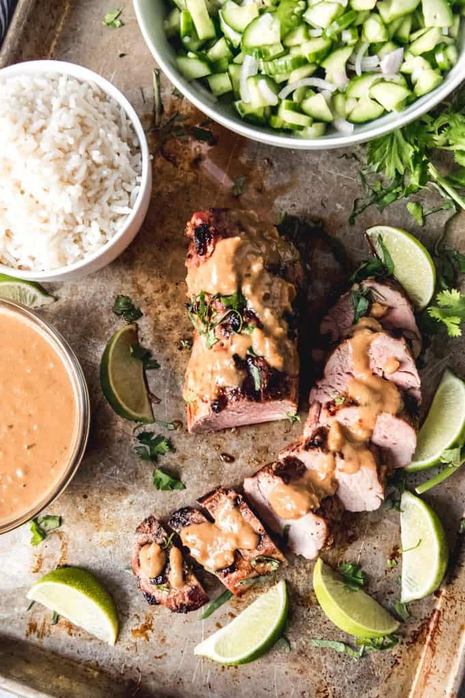 An image of a sliced pork tenderloin that has been marinated in a Thai-inspired coconut, ginger, lime, and peanut butter marinade, then grilled to medium-rare.
