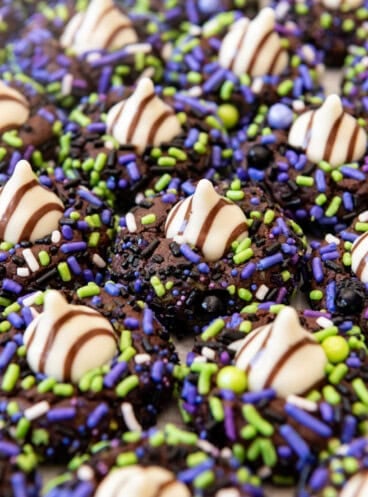 An image of chocolate sprinkle cookies with Hershey's Hugs candy pressed into the centers.