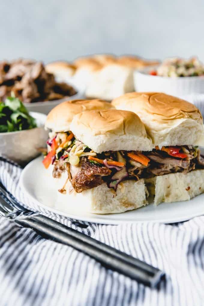 An image of a plate of easy sliders for a tailgating party made with Asian pulled pork, an Asian slaw recipe, and soft Hawaiian sweet roll buns.