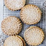 pizzelles on a wire rack with powdered sugar on top