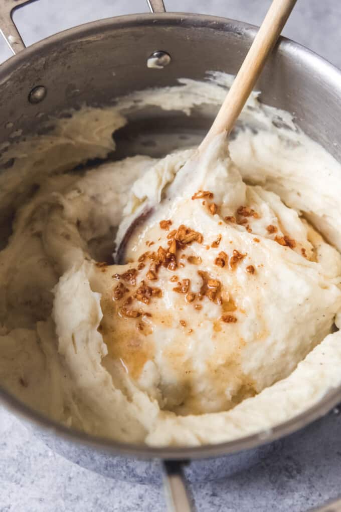 Adding browned butter to mashed potatoes.