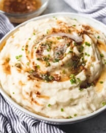 Garlic brown butter mashed potatoes in a bowl with garnish.