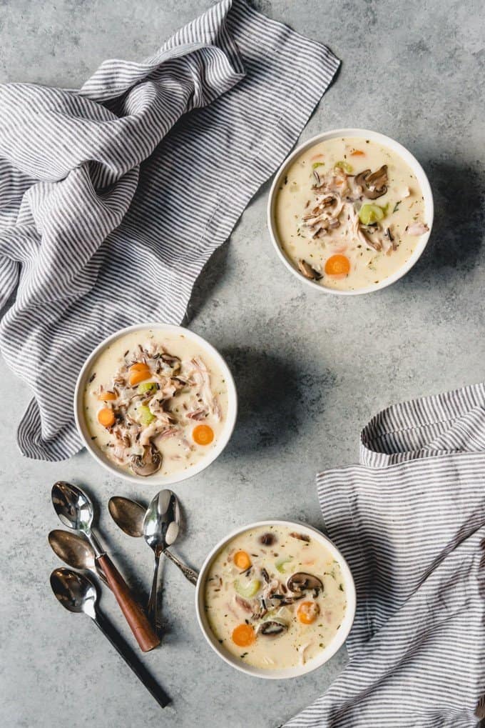 An image of bowls of easy turkey soup made with wild rice, vegetables, and leftover thanksgiving turkey.