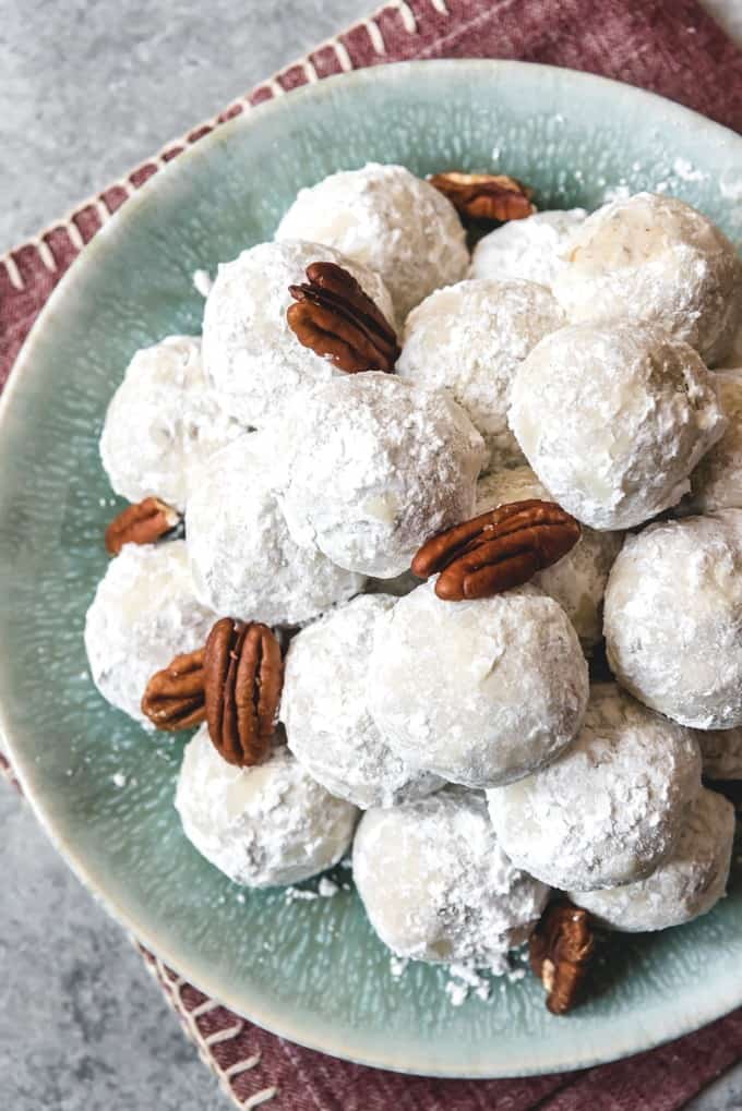 whole pecans on a plate with mexican wedding cookies