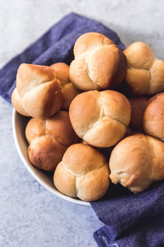 pull apart dinner rolls in a bowl with a blue towel