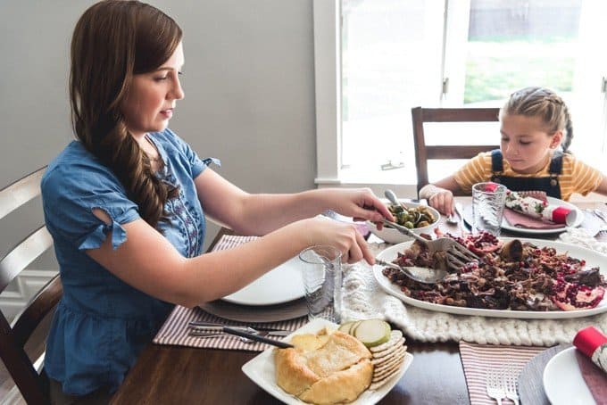 An image of a mother and daughter sitting at a table eating slow roasted lamb shoulder.