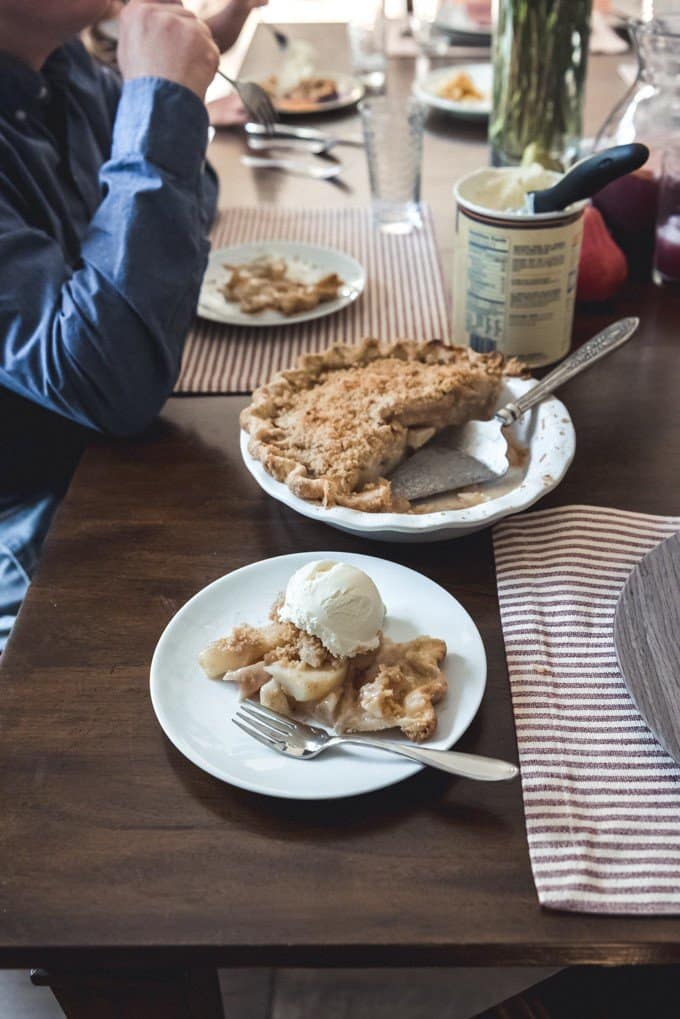 An image of a slice of dutch pear & nutmeg pie with a scoop of vanilla ice cream.