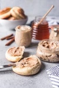 cinnamon honey butter spread on biscuits with more in jars to the side