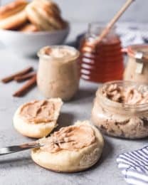 cinnamon honey butter spread on biscuits with more in jars to the side