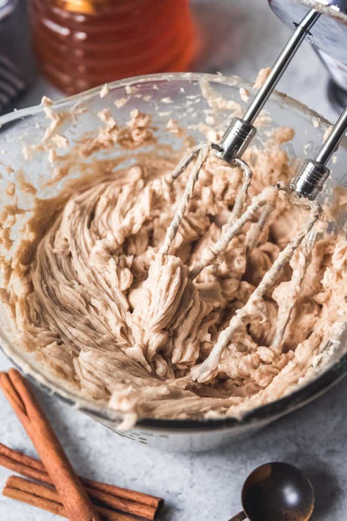 An image of whipped cinnamon honey butter in a bowl with beaters of a hand mixer.
