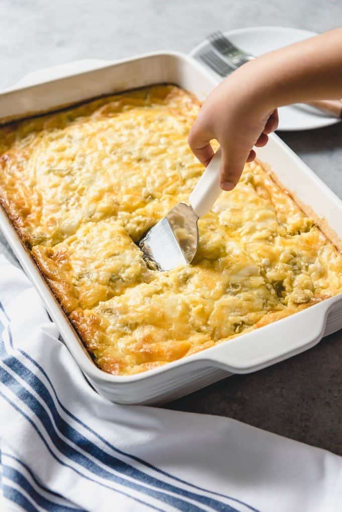 An image of an easy breakfast casserole in a large pan with eggs, cheese, cottage cheese, and green chilies for Christmas breakfast.