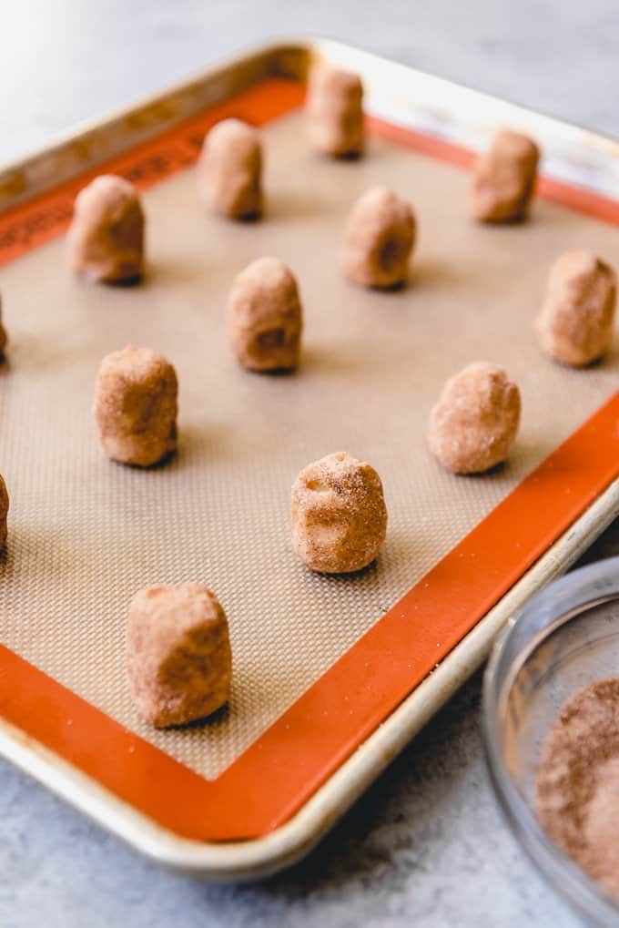balls of snickerdoodle dough on a silicone lined baking sheet