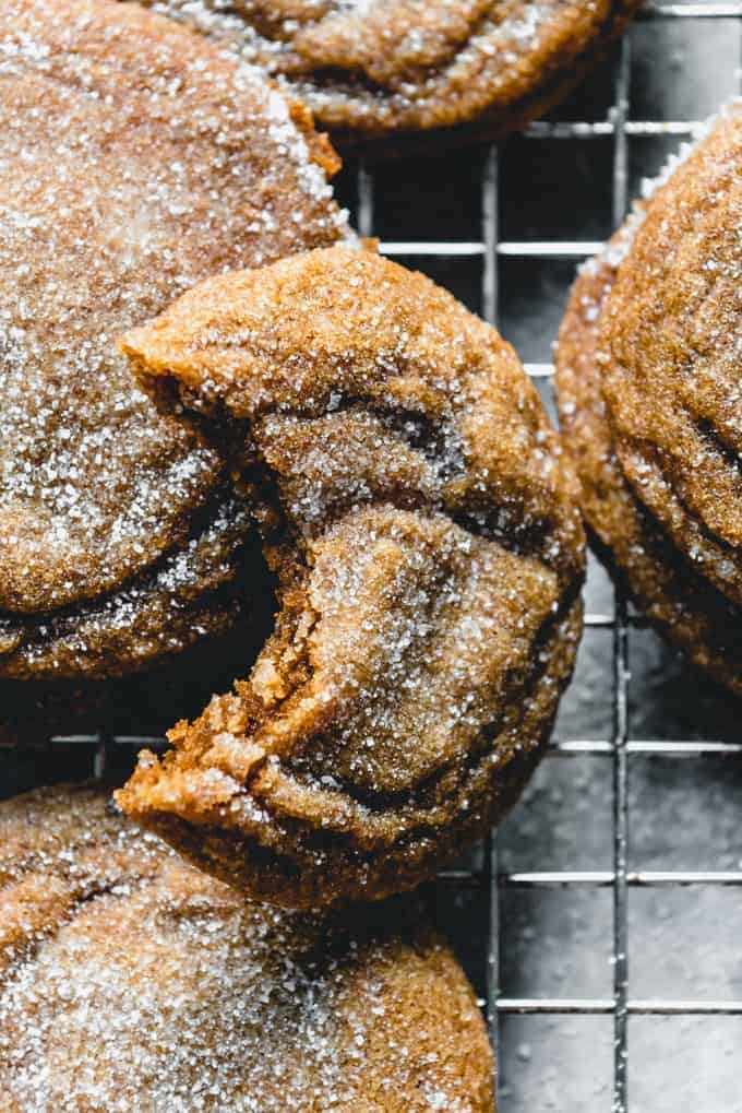 An image of a soft and chewy molasses ginger cookie with a bite taken out of it.