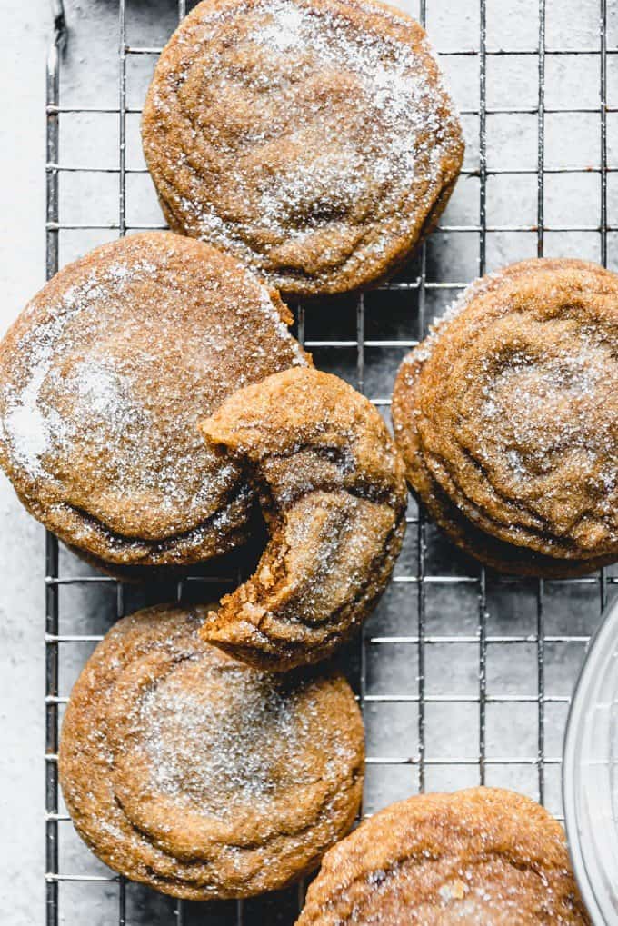 An image of old fashioned soft molasses cookies stacked on a wire cooling rack with one bite taken out of the top cookie.