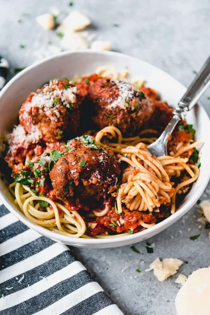 spaghetti and meatballs in a white bowl