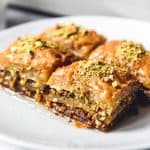 An image of four squares of Turkish pistachio baklava made with a sweet sugar syrup.