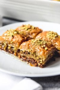 An image of four squares of Turkish pistachio baklava made with a sweet sugar syrup.