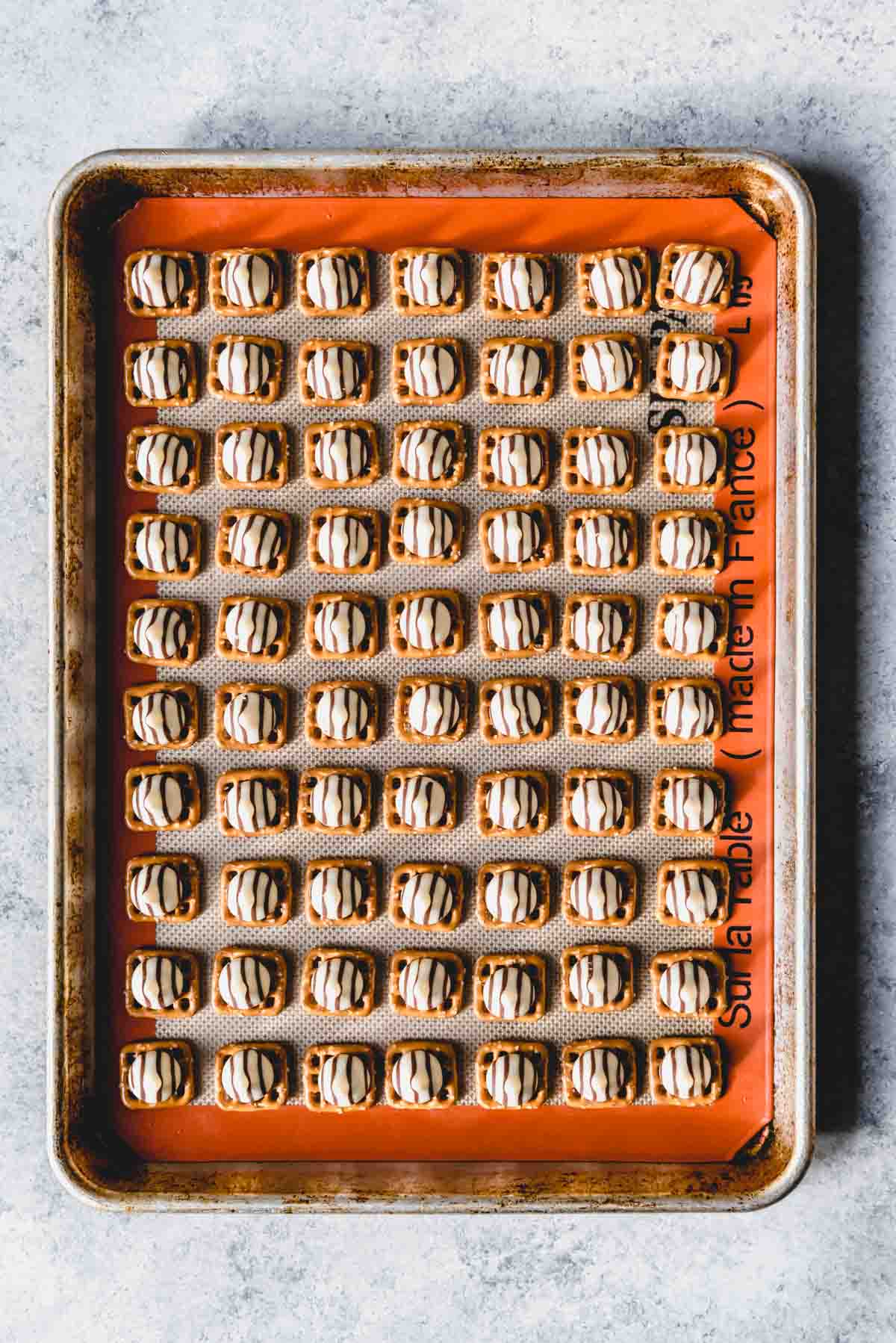 An image of Hershey's hugs on pretzels on a baking sheet.