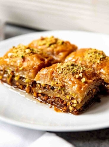 An image of four squares of Turkish pistachio baklava made with a sweet sugar syrup.