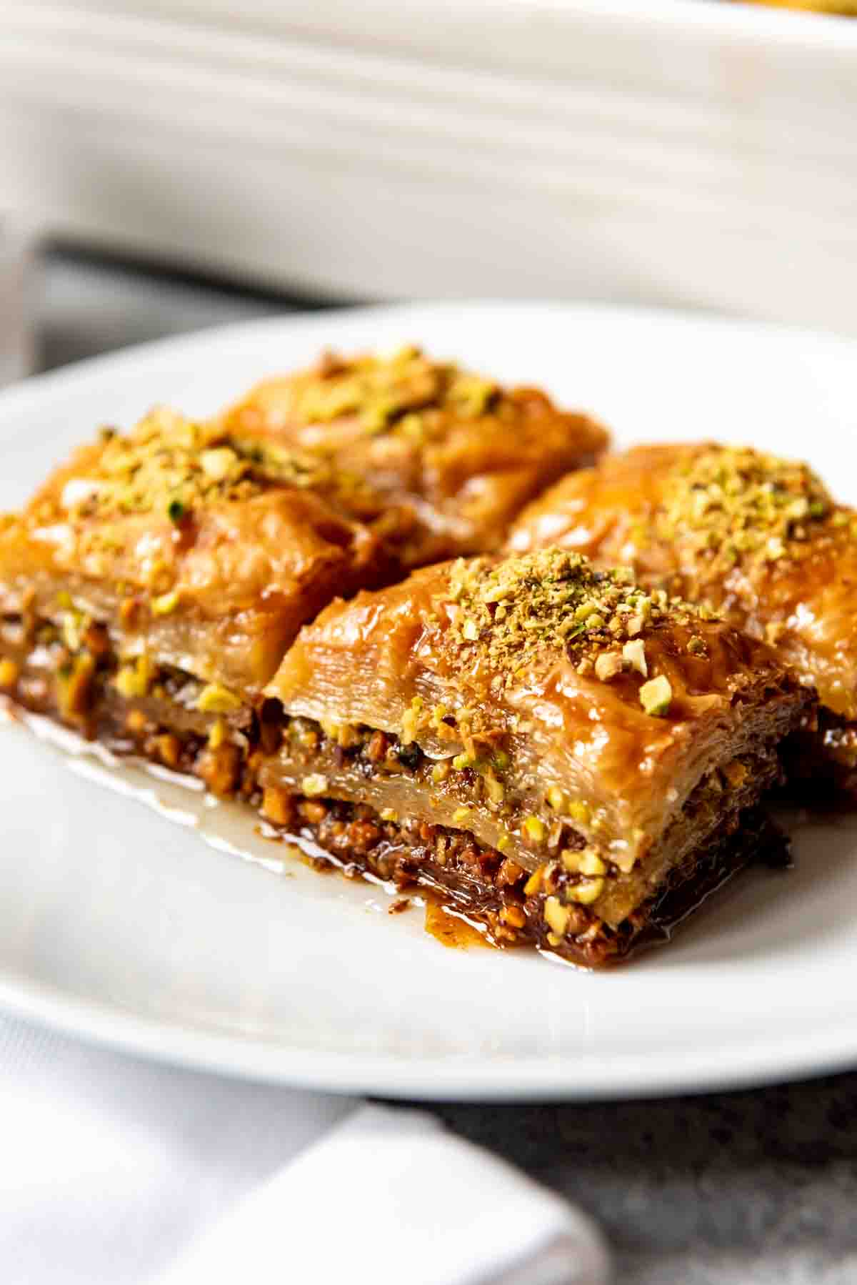 An image of four squares of Turkish pistachio baklava made with a sweet sugar syrup.