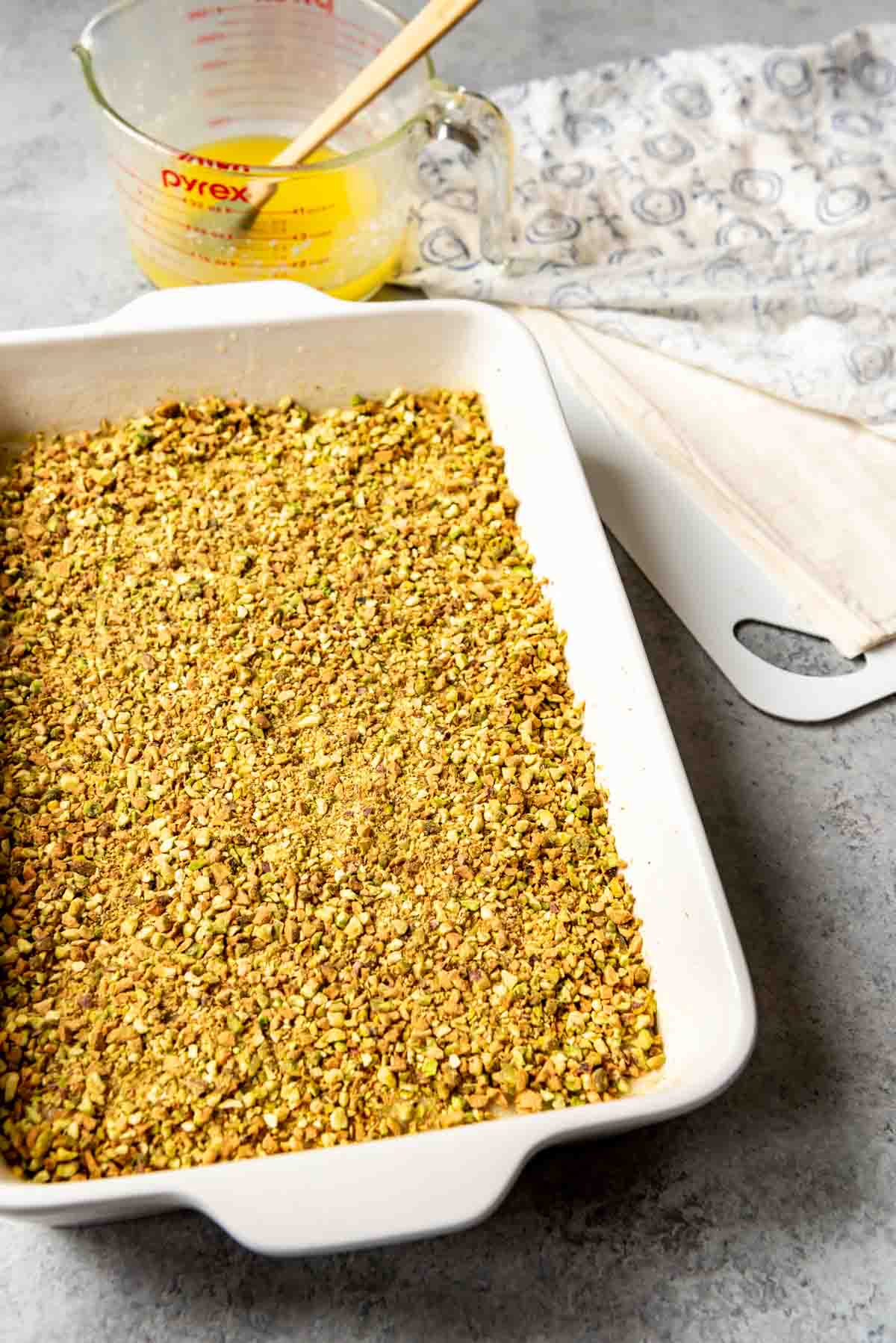 Adding more layers of pistachio and phyllo dough.