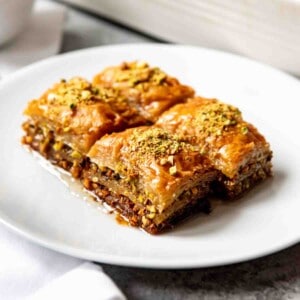 An image of four squares of Turkish pistachio baklava made with a sweet sugar syrup.