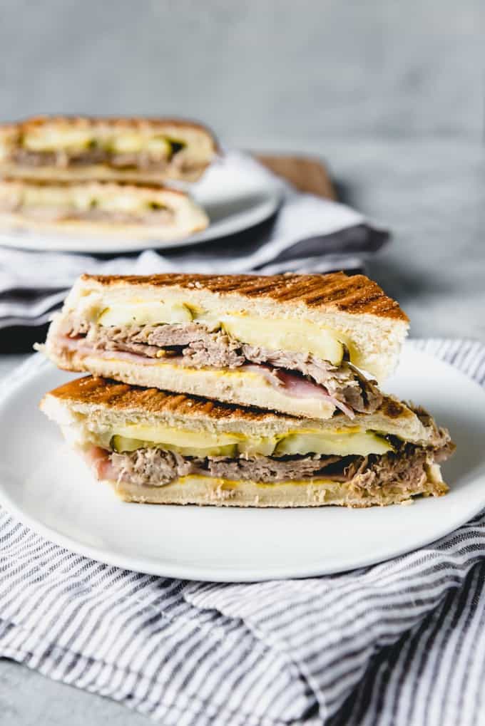 cut Cuban Sandwiches on white plates