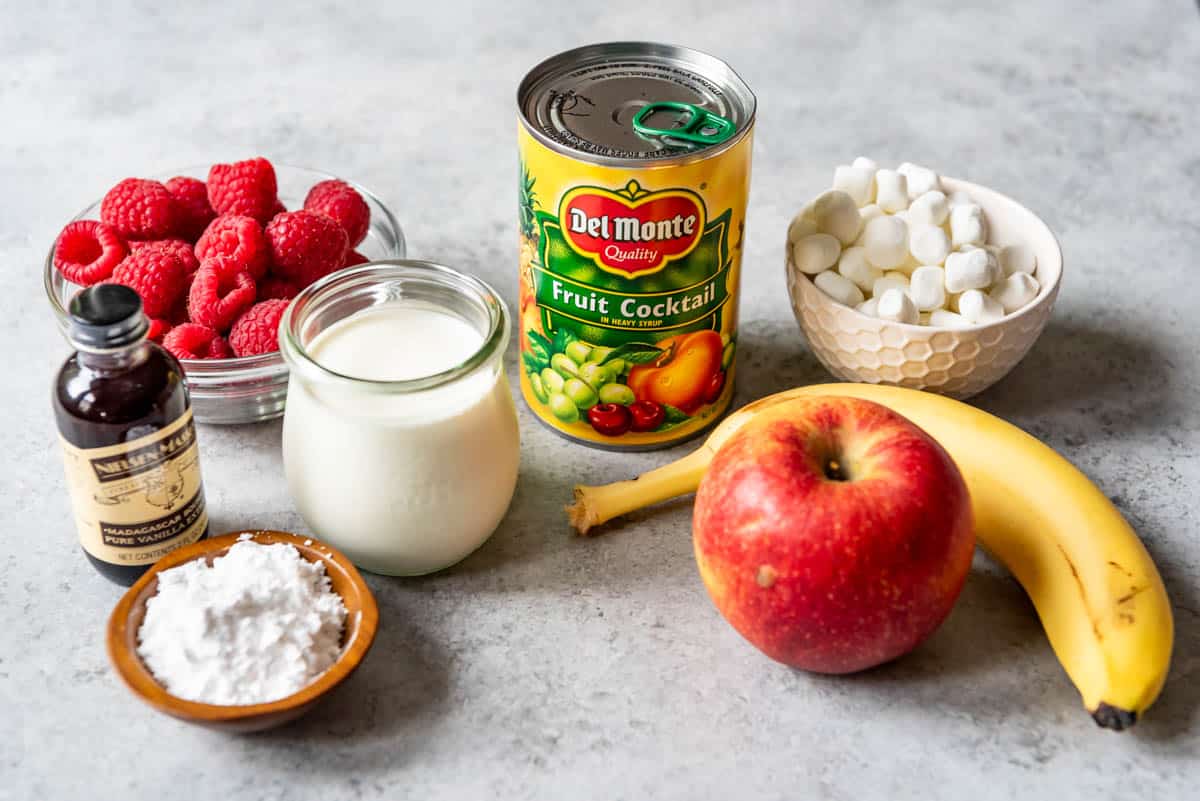An image of a can of fruit cocktail with the other ingredients for making fruit salad with whipped cream and marshmallows.