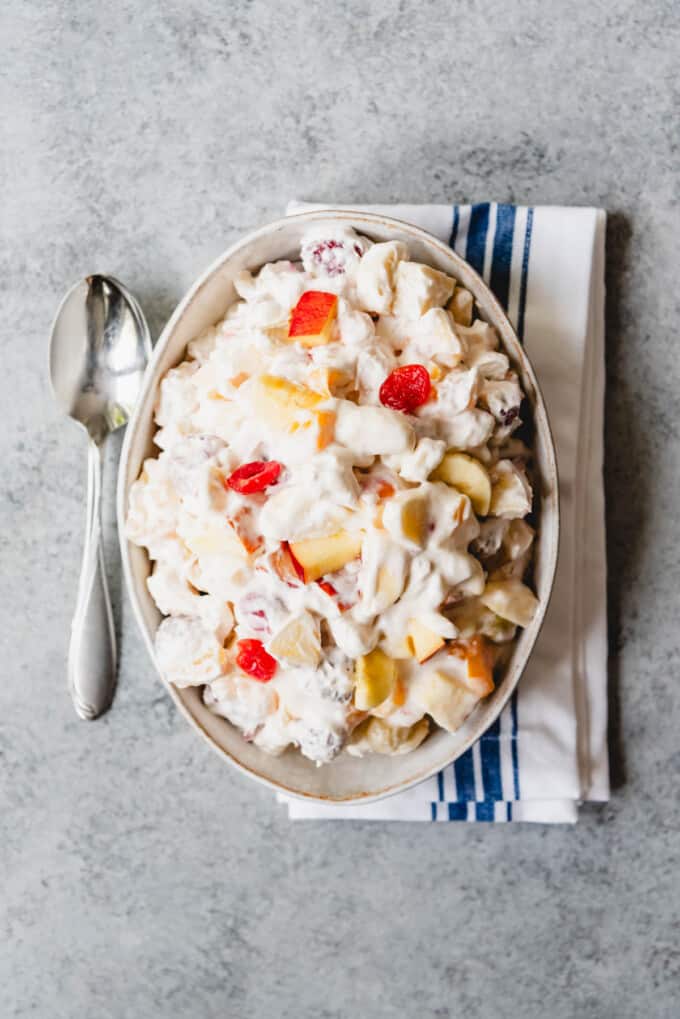 An image of a creamy fruit salad recipe in a bowl on a napkin.