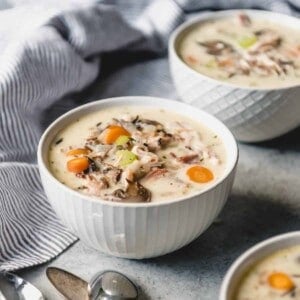 An image of bowls of creamy wild rice soup with leftover smoked turkey and vegetables in bowls.