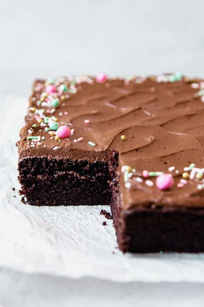 chocolate cake with chocolate frosting and sprinkles missing a slice