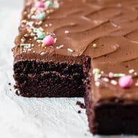 Frosted Chocolate cake with sprinkles missing a slice