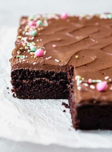 Frosted Chocolate cake with sprinkles missing a slice