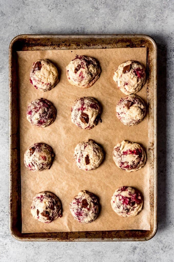 An image of raspberry chocolate chip cookies on a baking sheet.