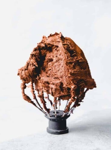 An image of a Kitchenaid whisk attachment with chocolate frosting on it.