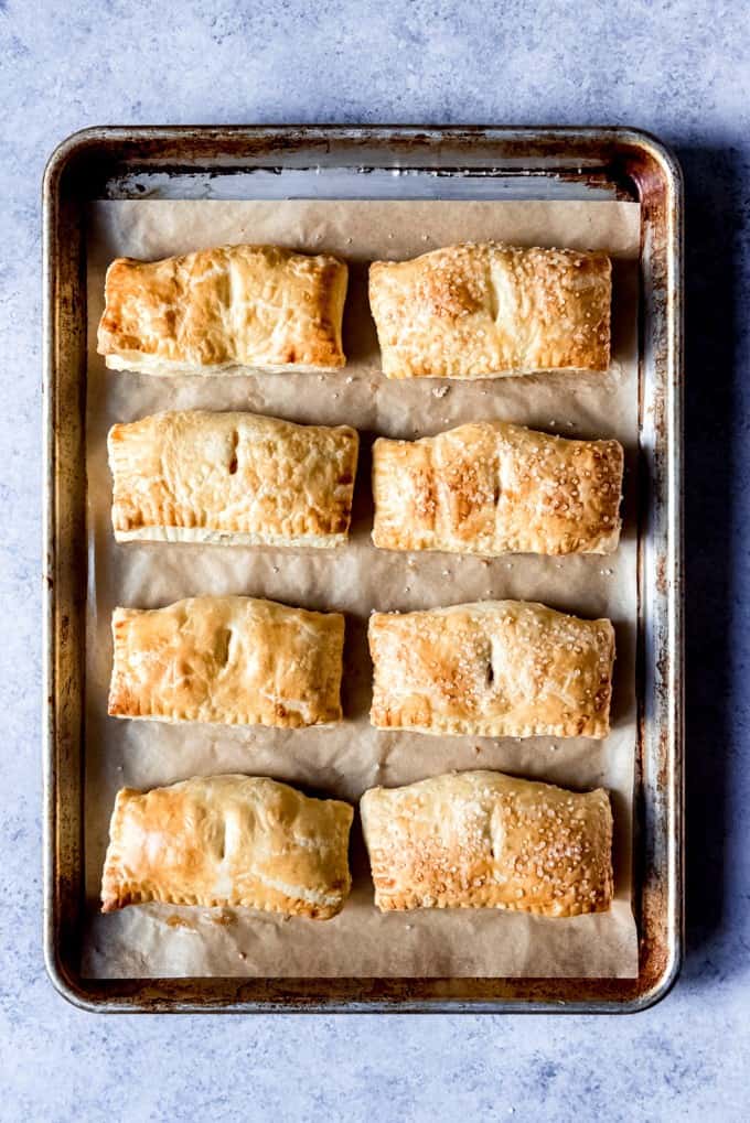 An image of a baking sheet full of golden Cuban pastries with guava and cream cheese.