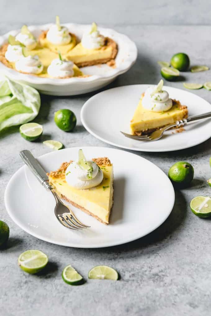 An image of a sliced key lime pie with fresh key limes surrounding it.