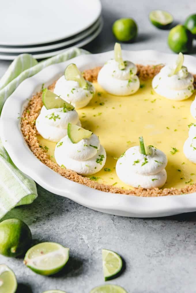 a key lime pie with whipped cream and garnished with keylimes