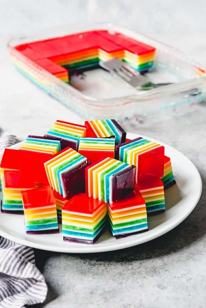 An image of a plate of stacked rainbow finger jello is a fun treat for rainbow parties, St. Patrick's Day, and other gatherings.